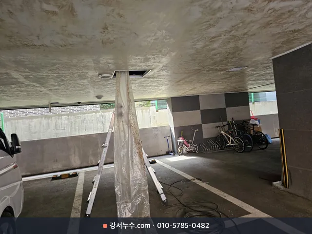주차장 천장 점검구에서 비닐로 물을 받아 내리는 장면
