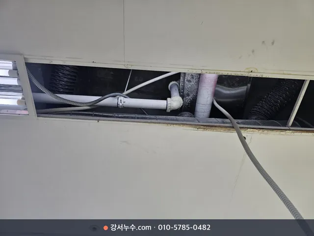 상가 천장 텍스를 열고 안쪽 배관을 확인하는 모습