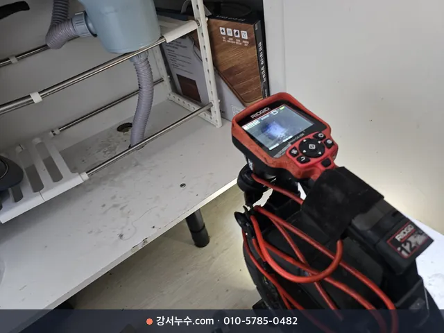 싱크대 하부 앞에서 내시경 모니터로 배관 내부를 확인